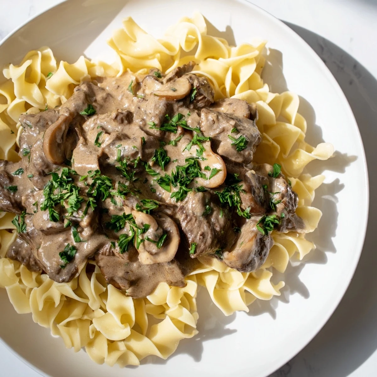 Rich, creamy beef stroganoff with a dark mushroom gravy, a classic home-cooked meal.
