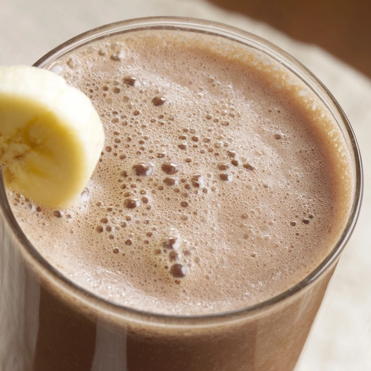 Homemade Chocolate Banana Smoothie with Milk poured into a glass, showing creamy texture and straw.