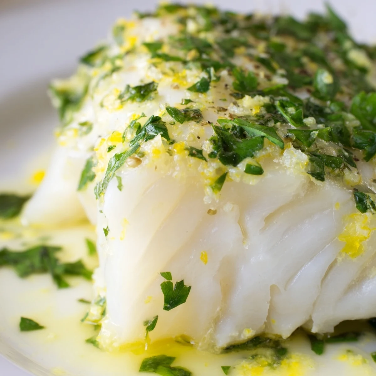 Tender baked cod fillets swimming in a vibrant lemon butter sauce, garnished with fresh parsley for a light, zesty main course.  