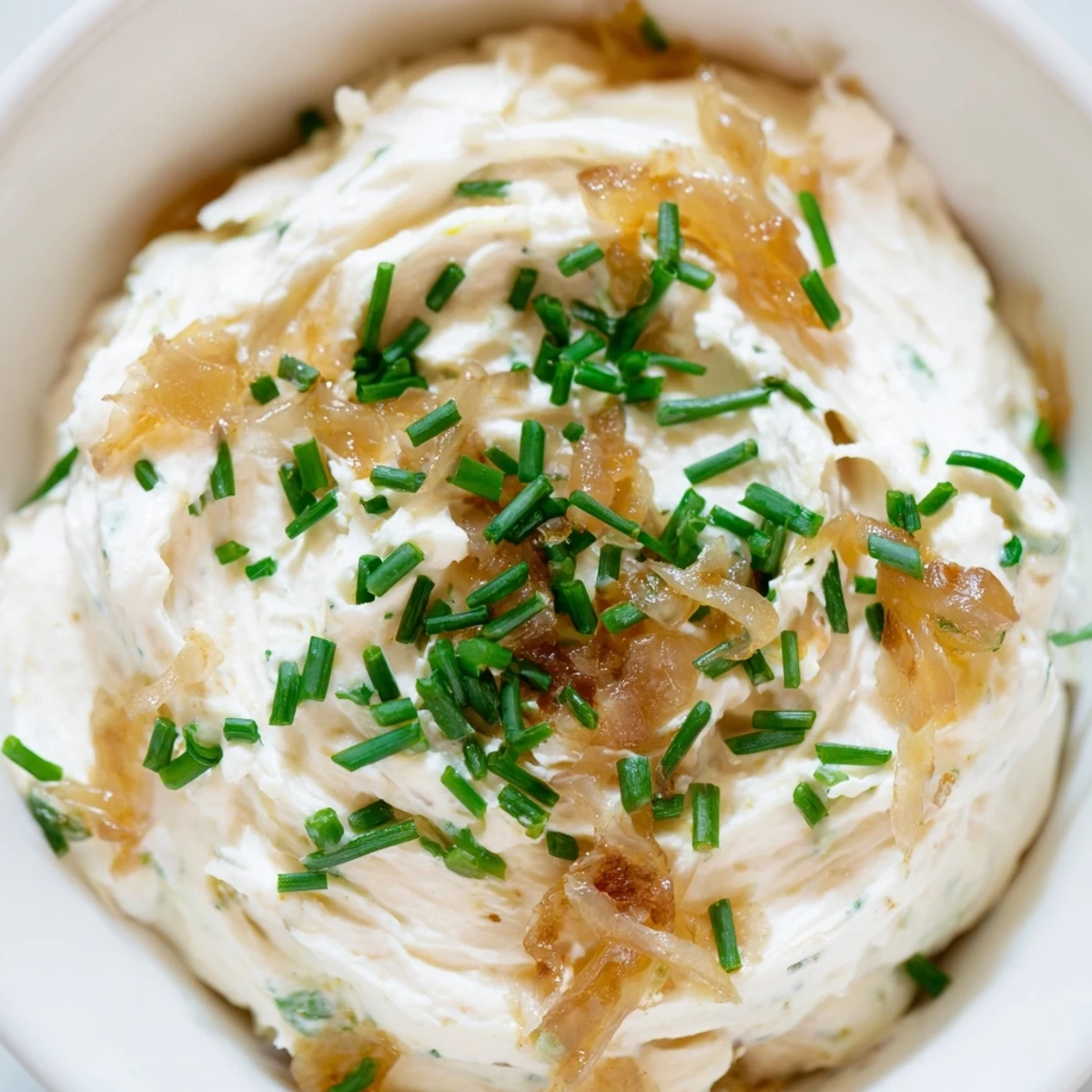 Rich Game Day Onion Dip in a bowl, paired with colorful veggie sticks for dipping.