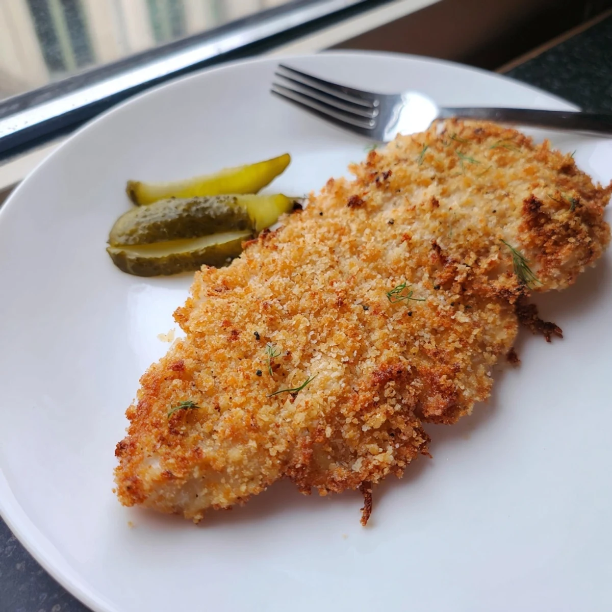 A close-up of baked or fried Crispy Dill Pickle Parmesan Chicken, perfectly seasoned and tender.
