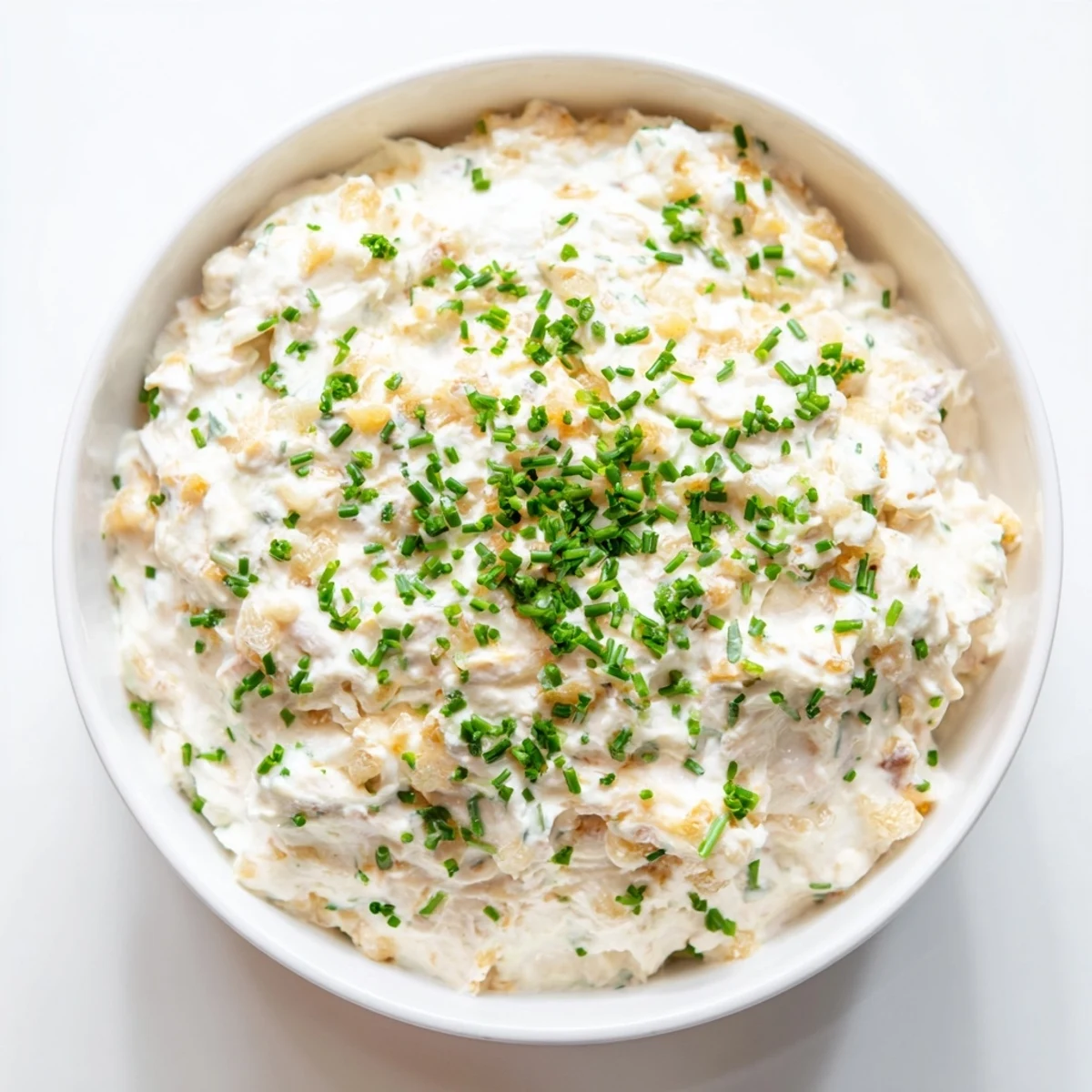 A close view of Game Day Onion Dip with Potato Chips and golden caramelized onions.