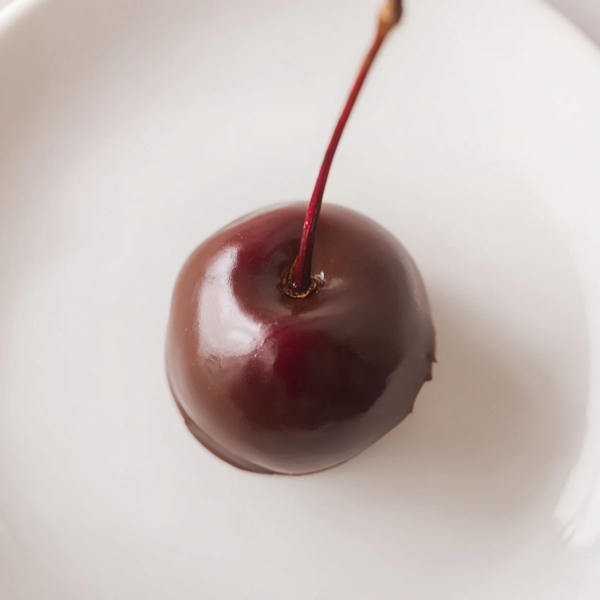 A close-up shot of Chocolate Covered Cherries with Fondant Center, where the rich chocolate coating contrasts beautifully with the smooth, pale fondant and bright cherry inside.