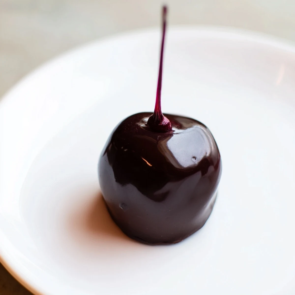 Plate of homemade Chocolate Covered Cherries with Fondant Center, arranged on parchment with a light dusting of powdered sugar, highlighting their bite-sized, handcrafted appearance.