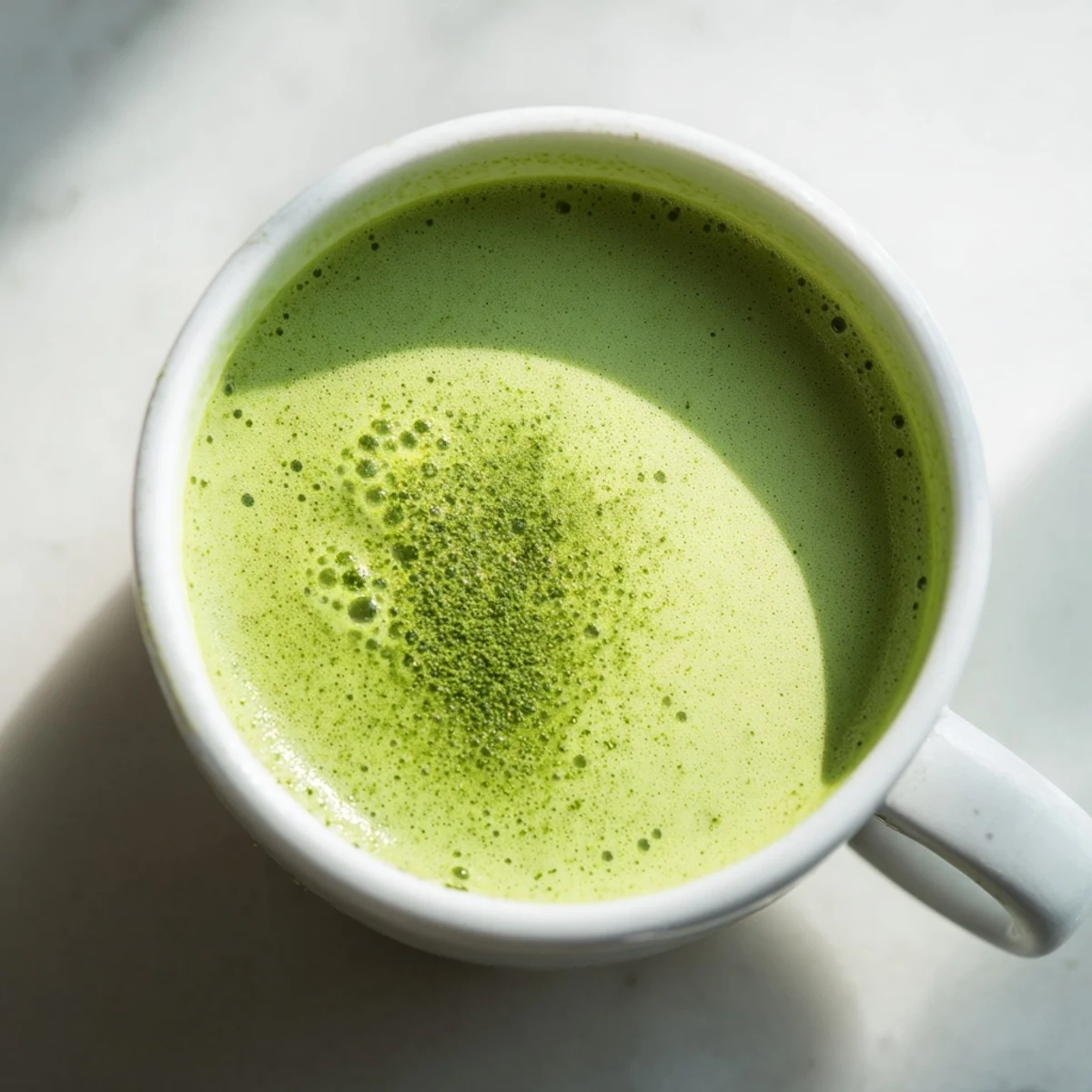 Steam rises from a creamy matcha oat milk latte, the honey-sweetened green tea inviting a soothing, dairy-free sip on a cozy morning.