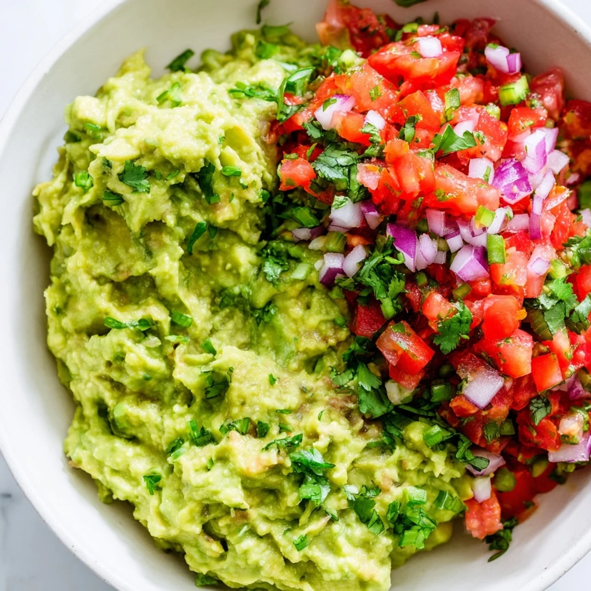 Creamy avocado dip with fresh pico de gallo and lime, ideal for parties or as a taco topping.