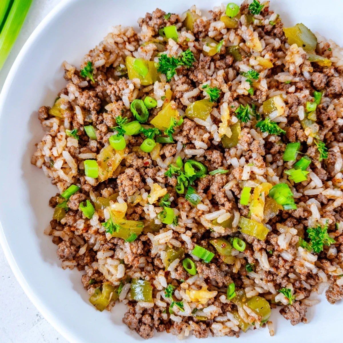 A hearty skillet of Cajun dirty rice with ground beef, served warm and garnished with parsley, ideal for a comforting Southern-style weeknight dinner.