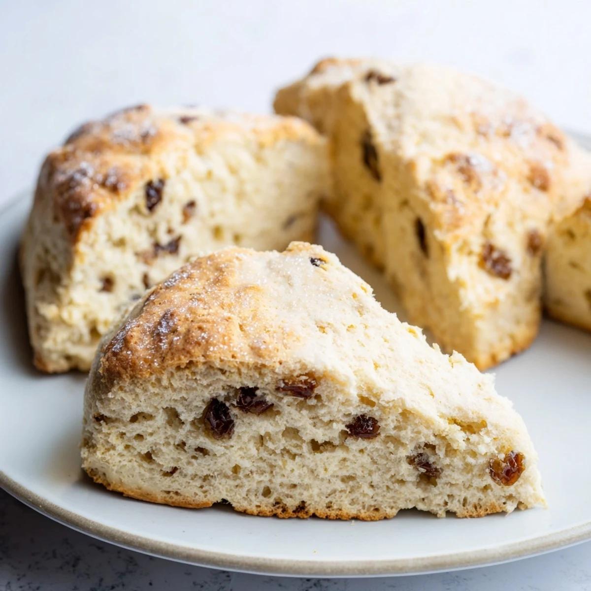Warm Irish Soda Bread Scones with Currants ready to be served alongside a cup of hot tea and Irish butter. 