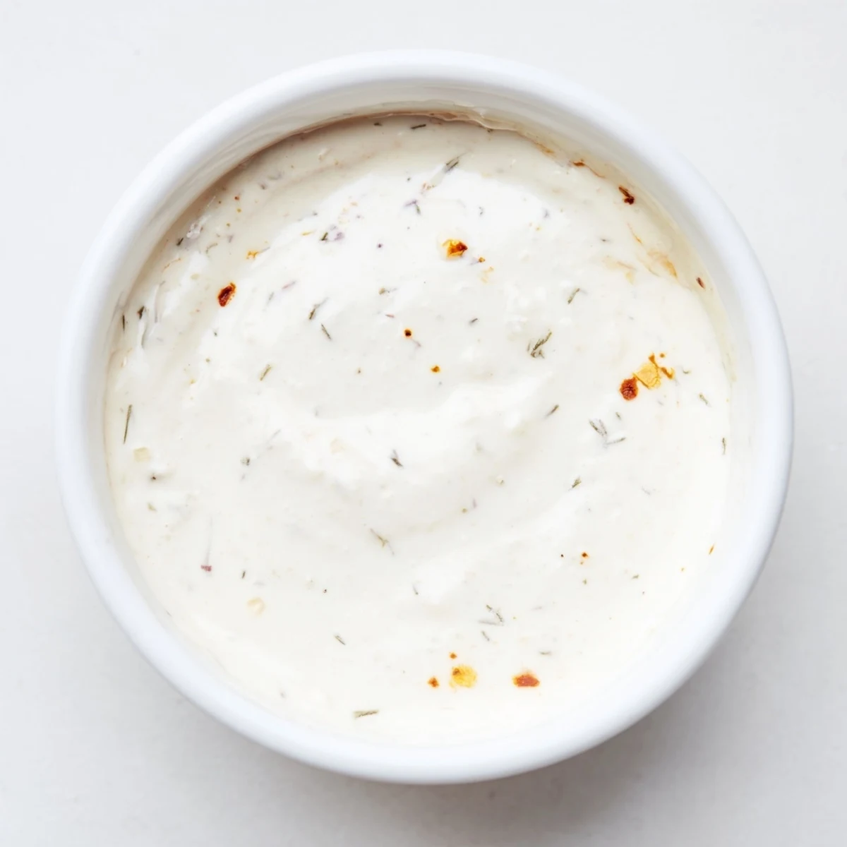 Dip into this hot honey ranch crispy chicken tenders sauce, garnished with dill and paprika.