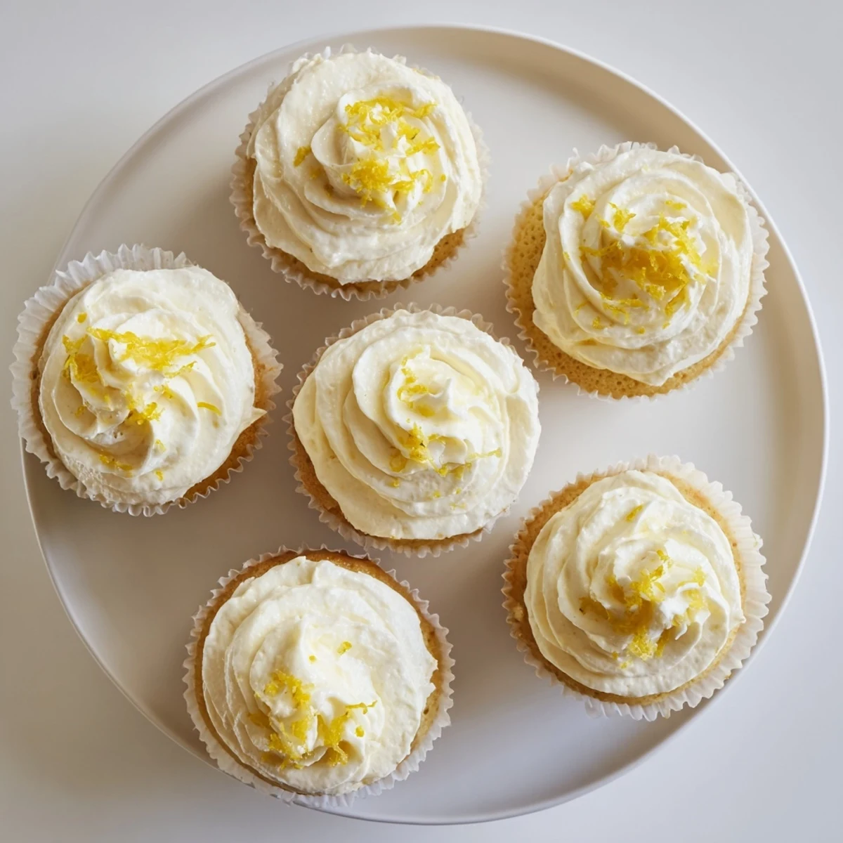 A close-up of Limoncello Cupcakes showing fluffy crumb, zesty garnish, and Italian-inspired dessert styling.