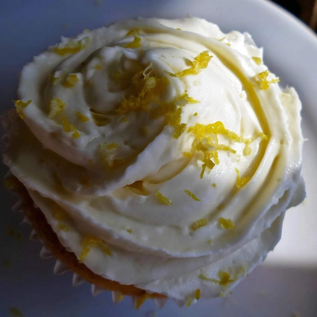 Golden-brown Limoncello cupcakes sit on a dessert platter, highlighting their zesty aroma and light, fluffy texture.