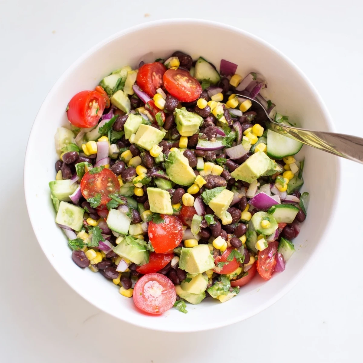 Protein-packed chopped black bean salad with vibrant vegetables, corn kernels, and cilantro dressed in tangy lime vinaigrette