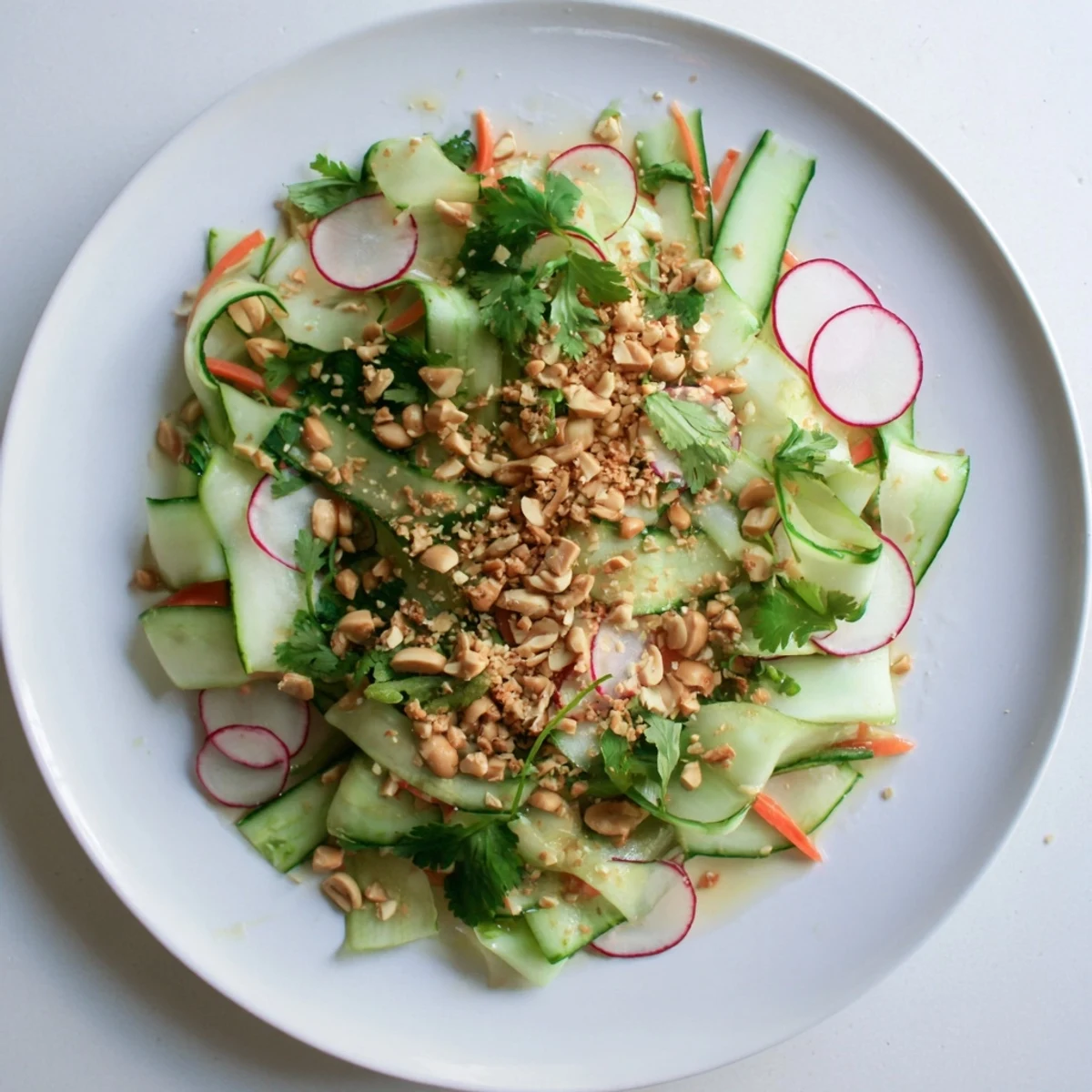 Vibrant julienne cucumbers and carrots drizzled with zesty sesame ginger sauce and toasted seeds