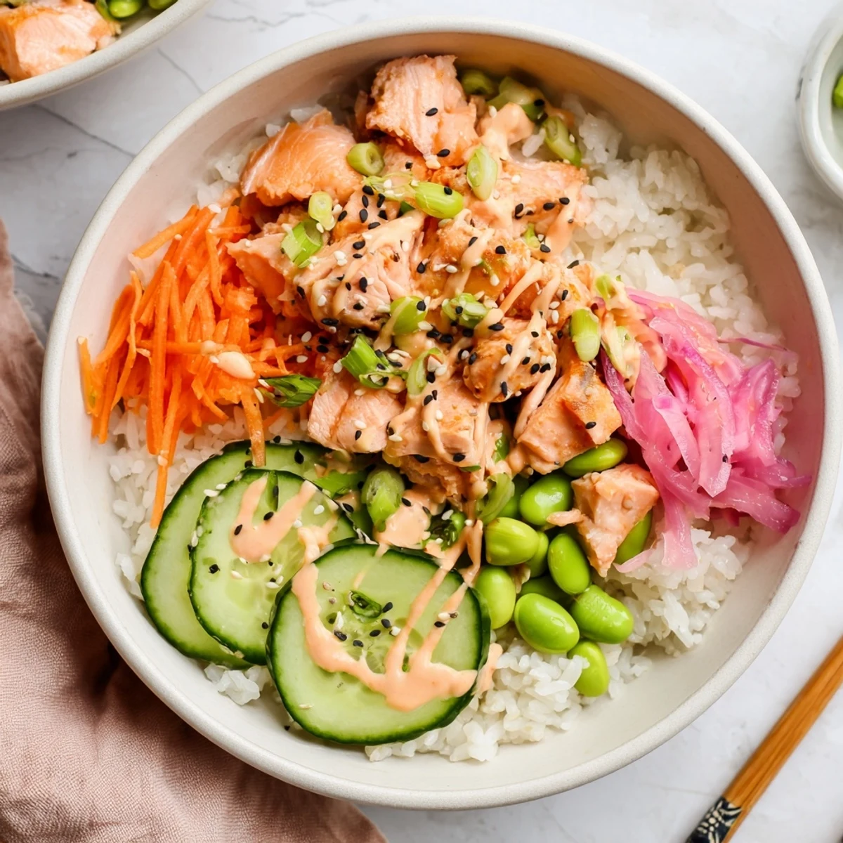Nutritious easy salmon bowl arranged with rice, fresh veggies, and creamy sesame topping