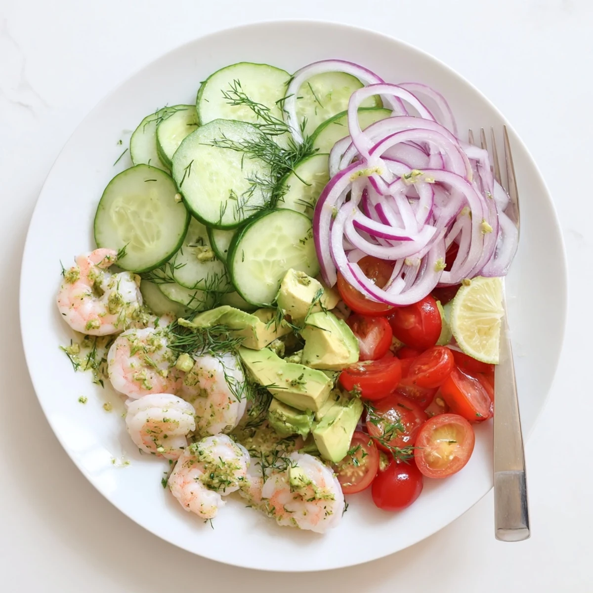 Colorful summer salad featuring plump shrimp, crunchy cucumbers, and red onion in citrus marinade