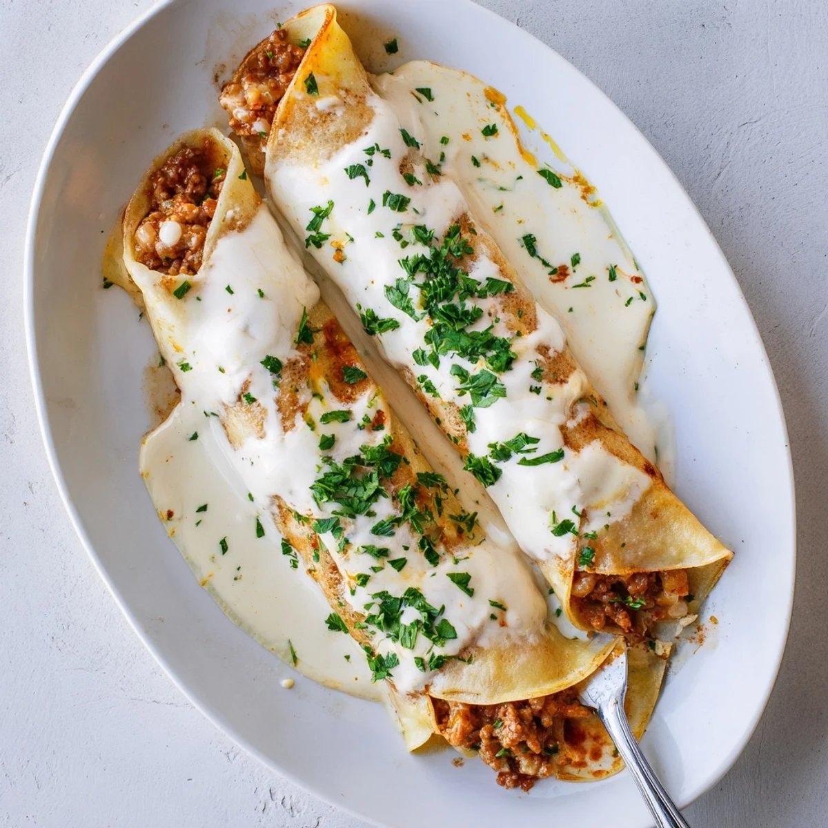 Traditional Hortobágyi palacsinta featuring tender crepes filled with seasoned meat ragout baked until golden under a velvety cream sauce