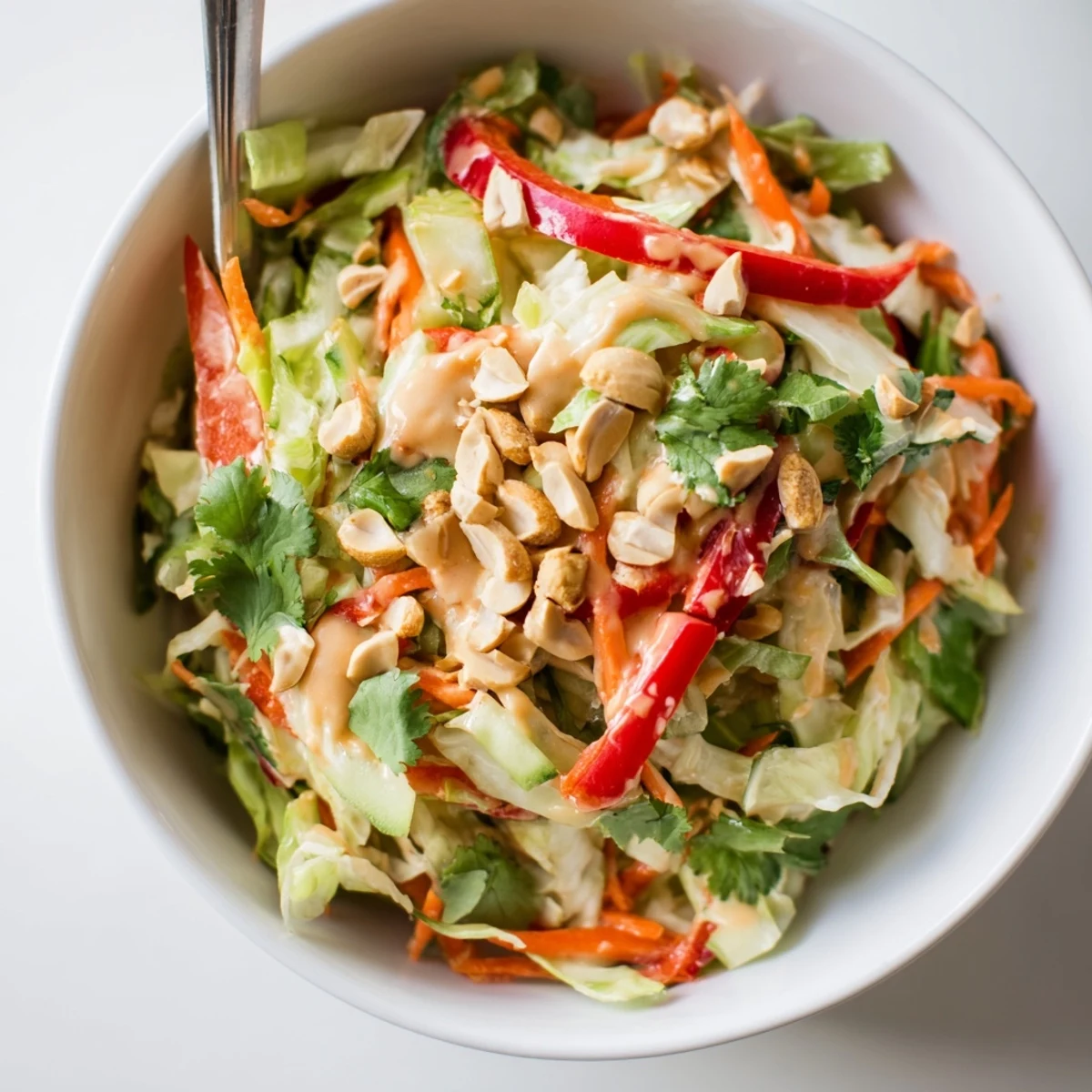 Fresh vegetable salad topped with creamy Thai peanut sauce and chopped roasted peanuts