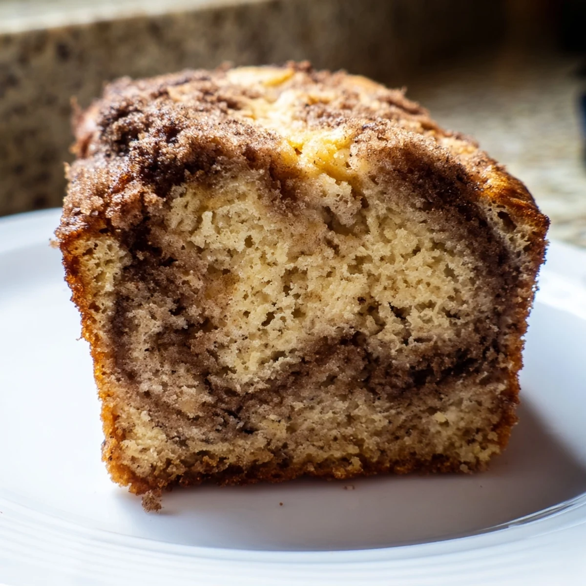 Warm cinnamon sugar swirl banana bread with caramelized crust cooling on wire rack ready for slicing