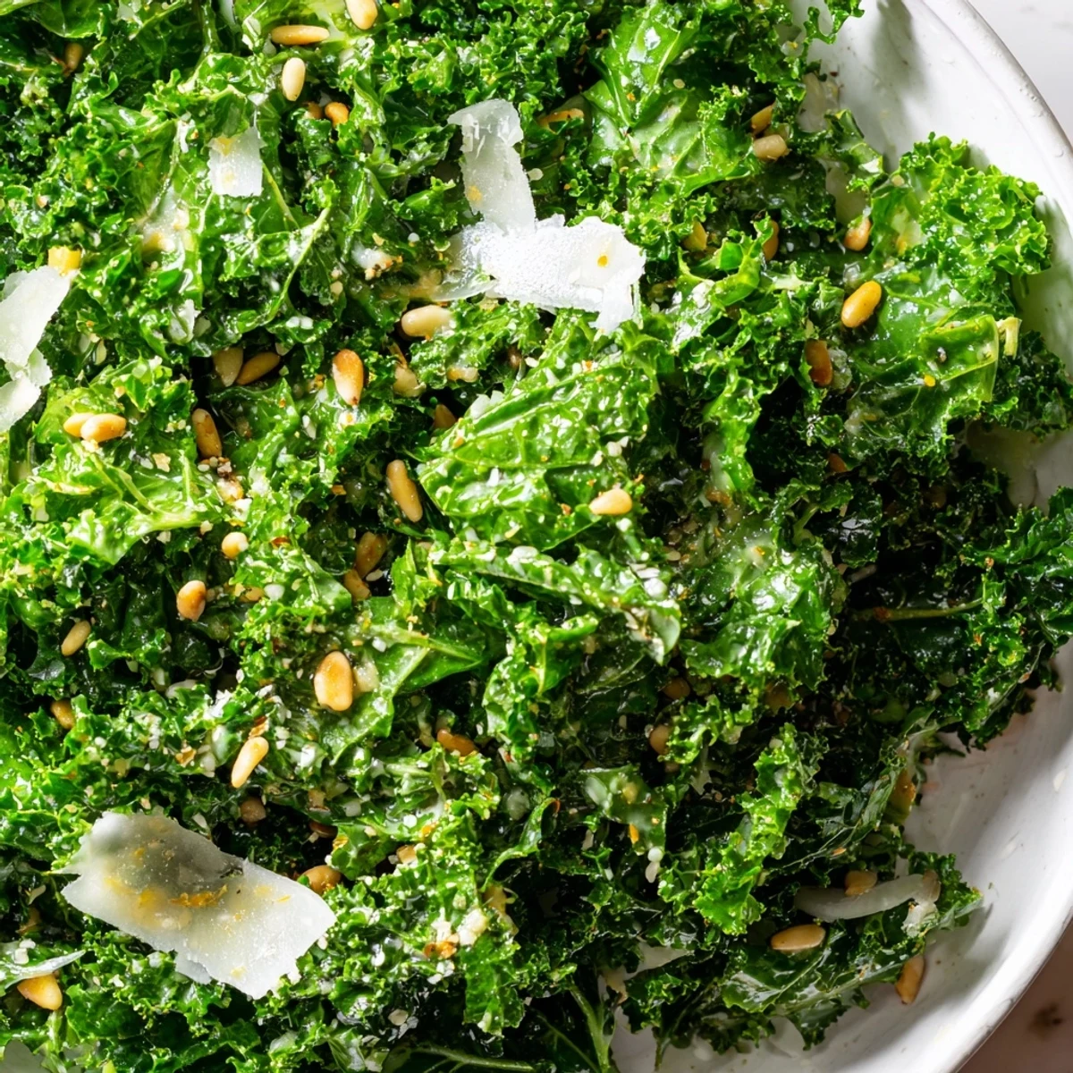 Fresh Garlic Lemon Parmesan Kale Salad in a rustic wooden bowl with shaved cheese