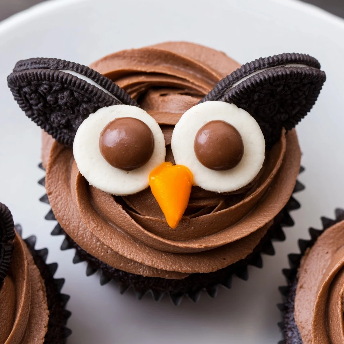 Adorable Oreo Owl Cupcakes featuring twisted cookie eyes and bright orange candy beaks