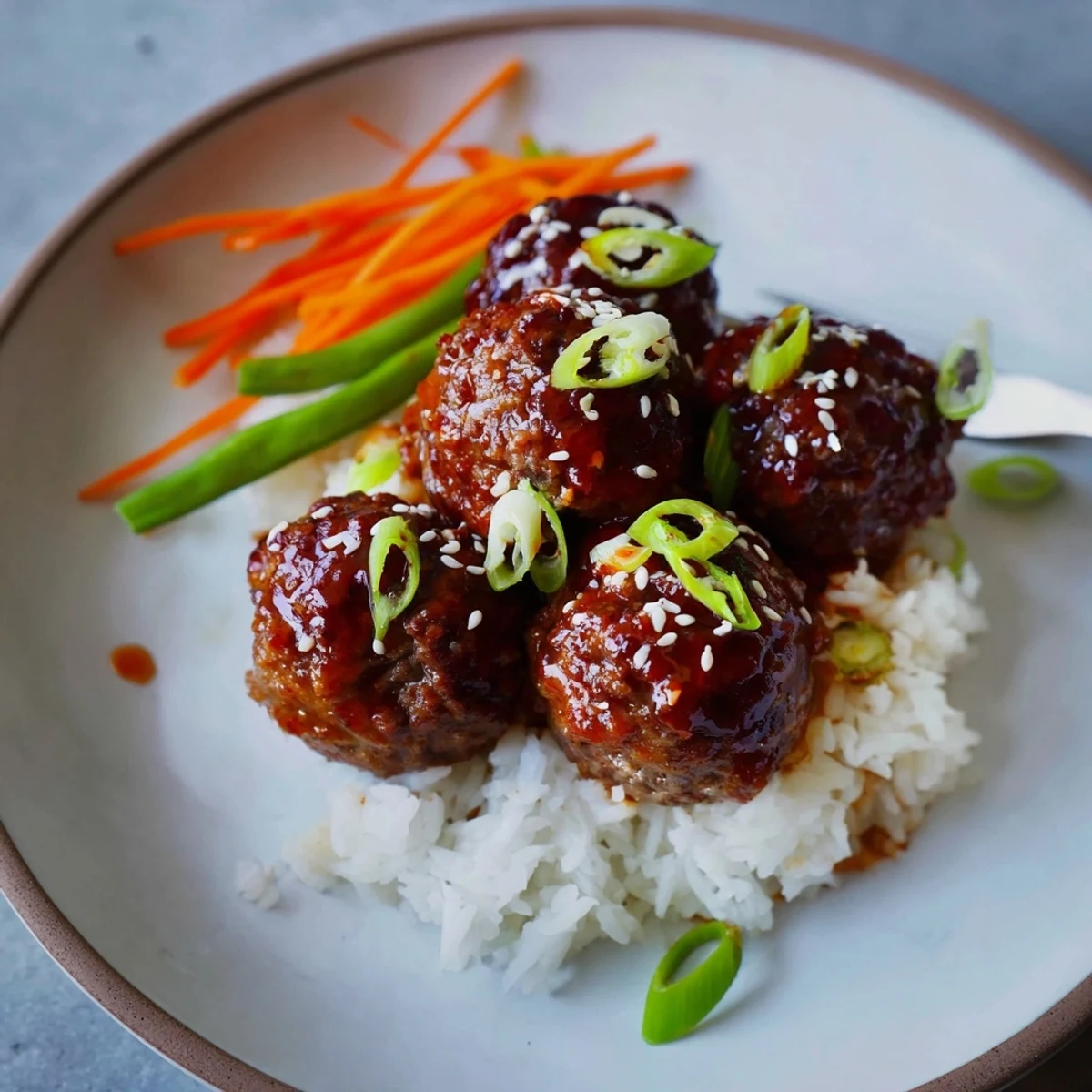 Plate of Hello Fresh Firecracker Meatballs beside crisp sautéed vegetables and rice