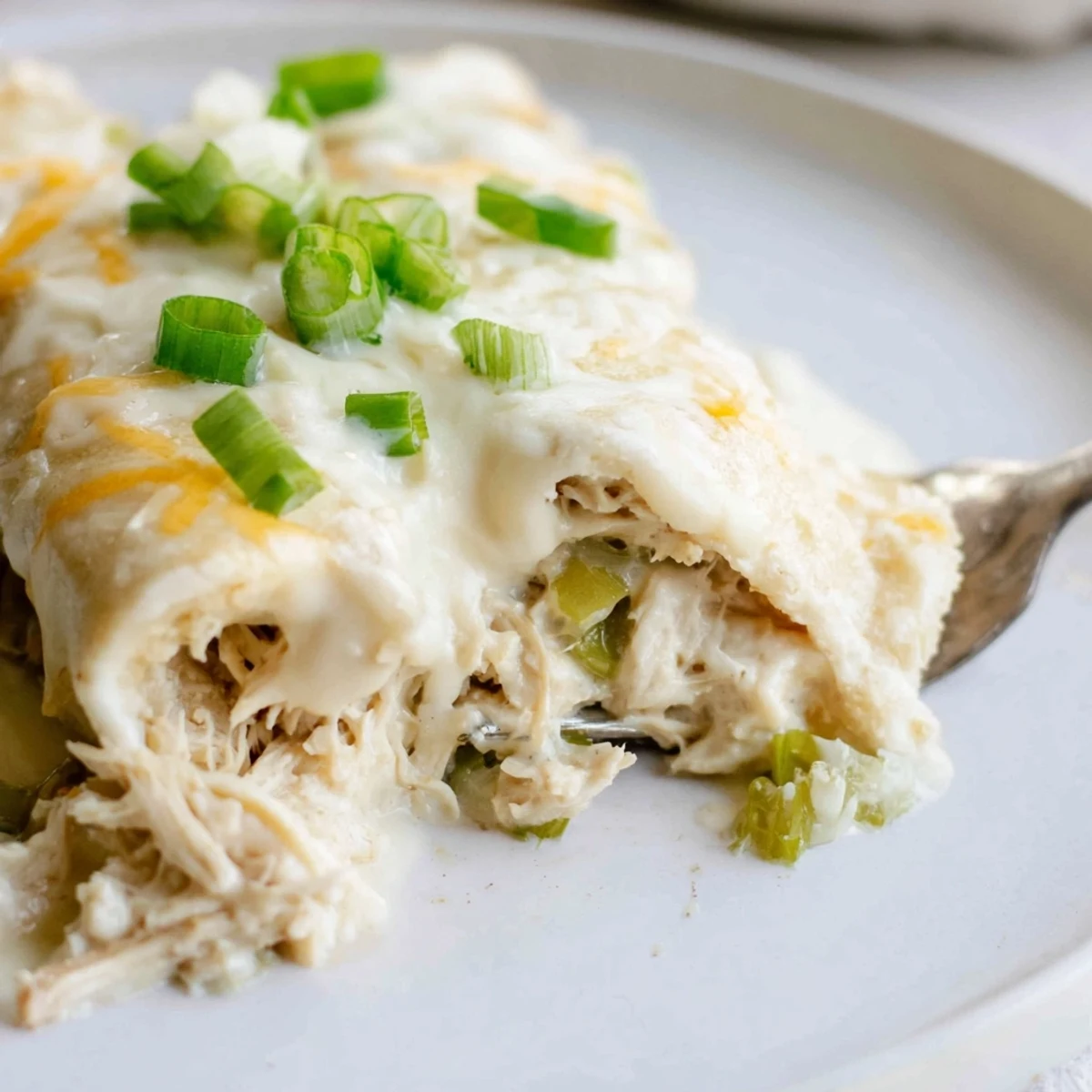 Creamy White Chicken Enchiladas bubbling with melted cheese and golden baked edges.
