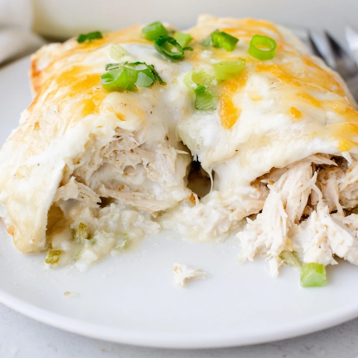 Warm Creamy White Chicken Enchiladas sliced open, tender chicken and tangy chilies.