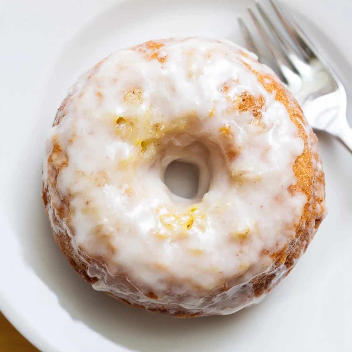 Golden Banana Donuts dusted with powdered sugar, served beside coffee mug.