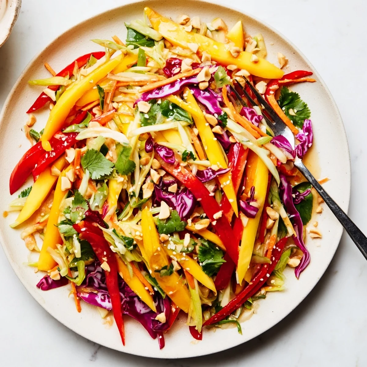Colorful tropical refreshing mango slaw topped with sesame seeds on a rustic wooden table.