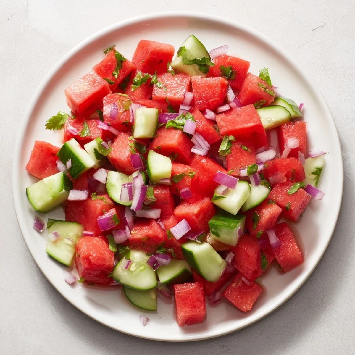 Sweet and spicy watermelon salsa in a white bowl next to golden cinnamon-dusted tortilla wedges