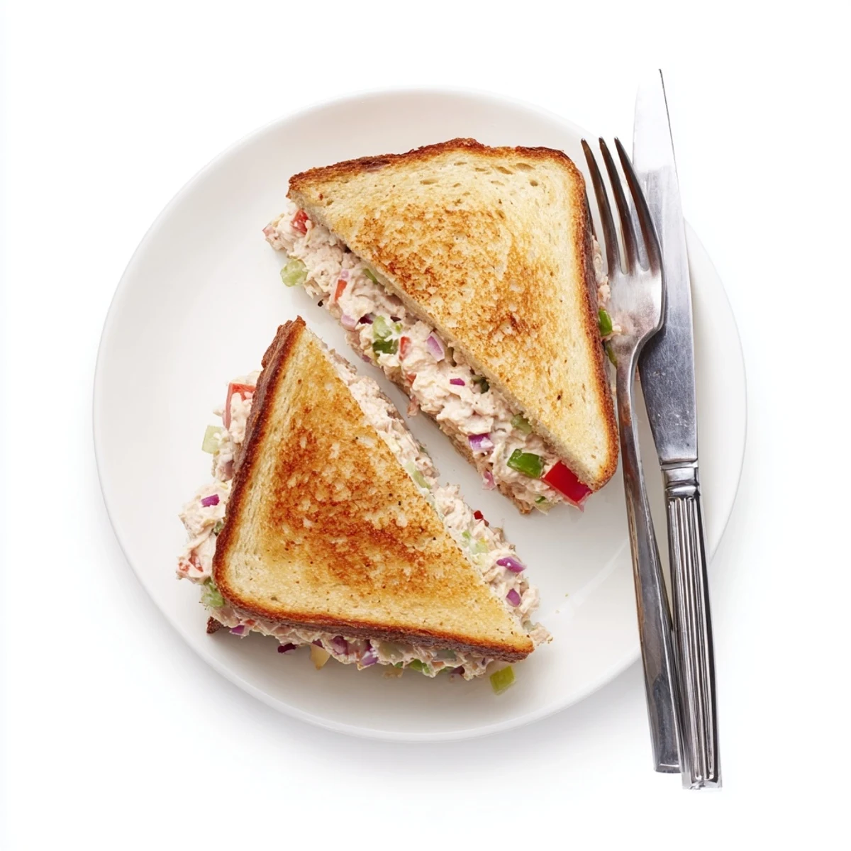 Classic American tuna melt on toasted bread with bubbling cheddar cheese and crisp red onion