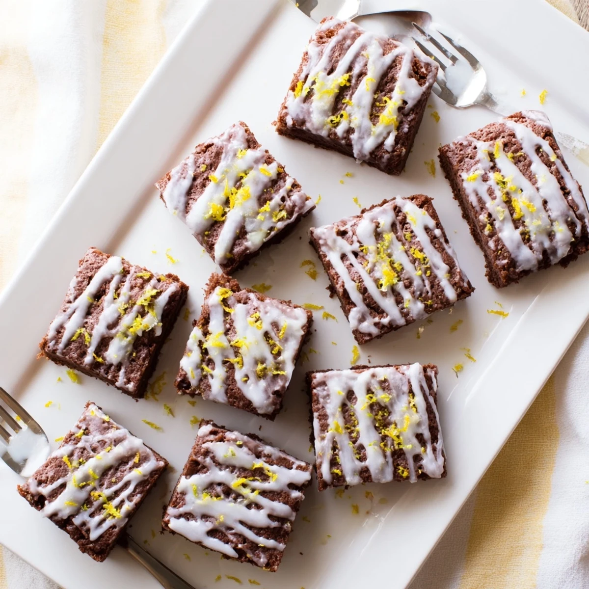 Fudgy lemon brown bars plated with fresh lemon zest garnish and vanilla ice cream