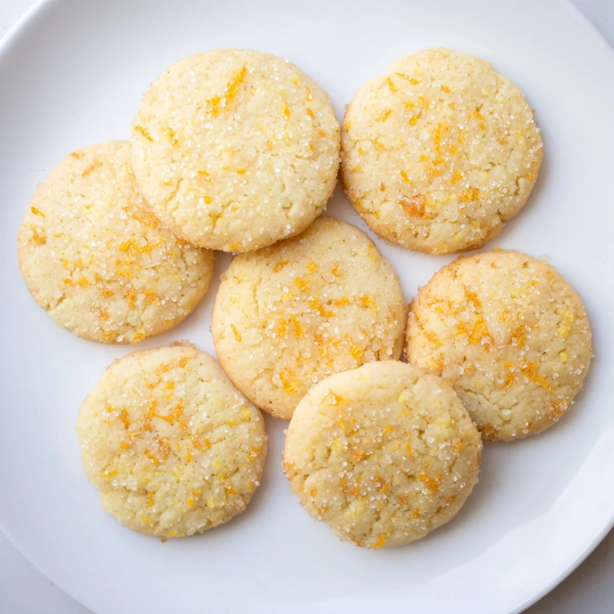 Buttery orange sugar zest cookies cooling on a wire rack with sugary tops