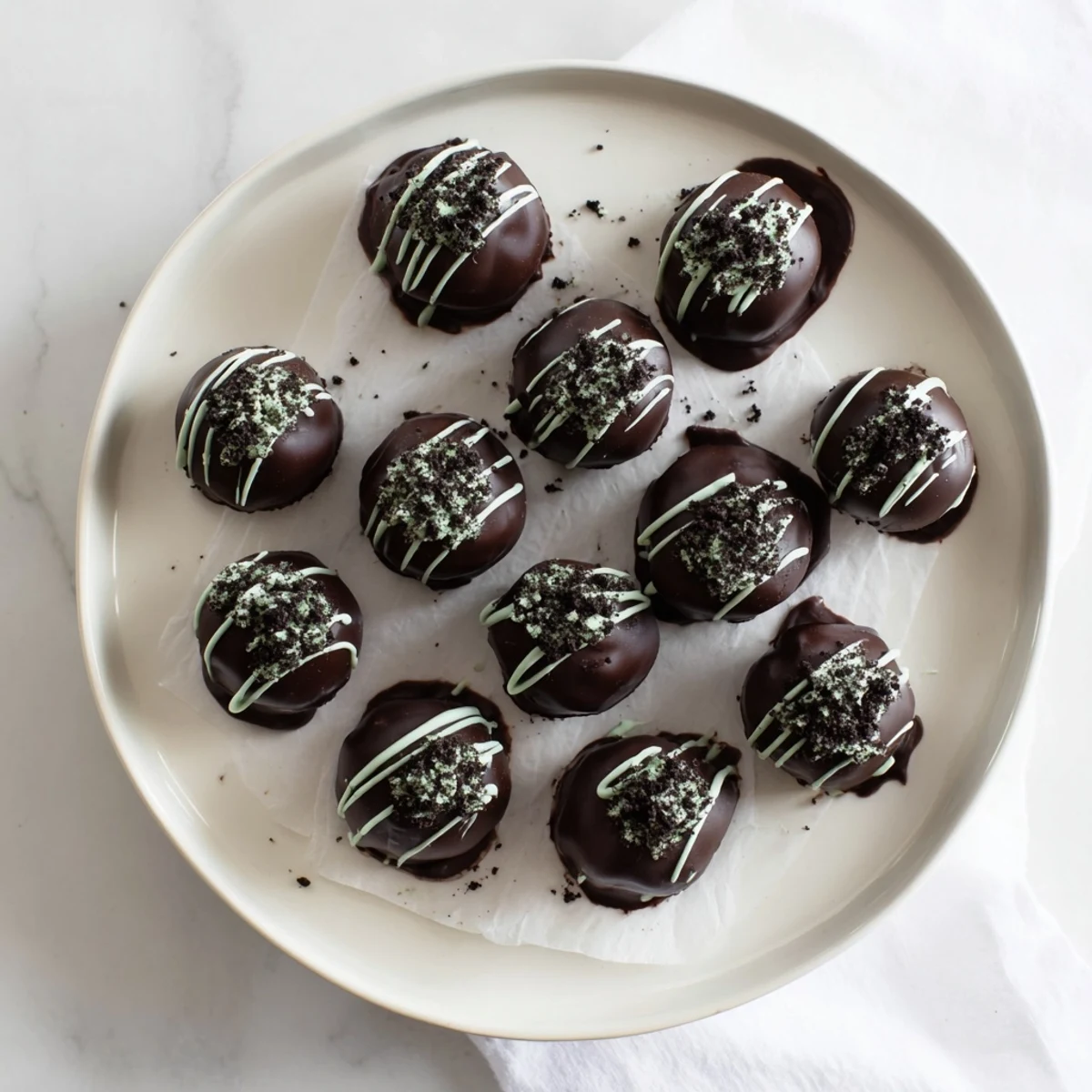 Rich chocolate-dipped mint Oreo truffles arranged on a decorative serving platter