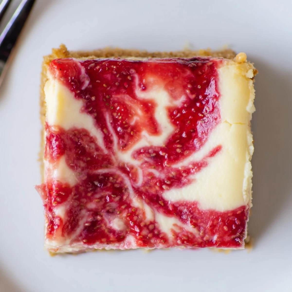 Velvety chilled slices of Irresistible Strawberry Swirl Cheesecake Bars on plate