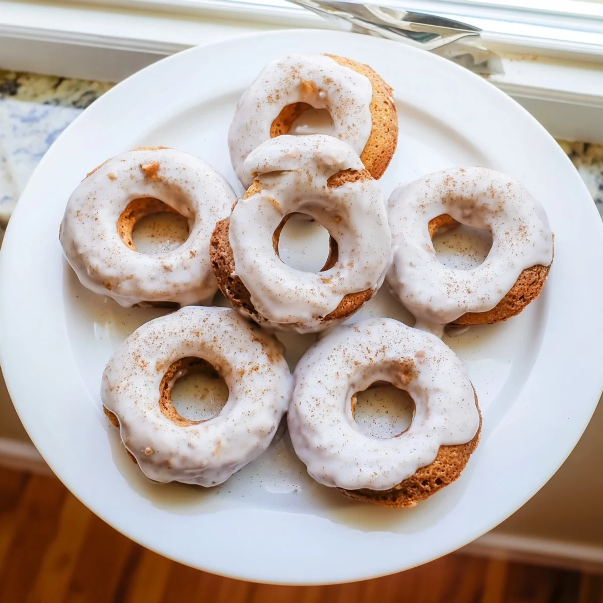 Freshly baked banana bread donuts with cinnamon sugar coating arranged on a wooden serving board