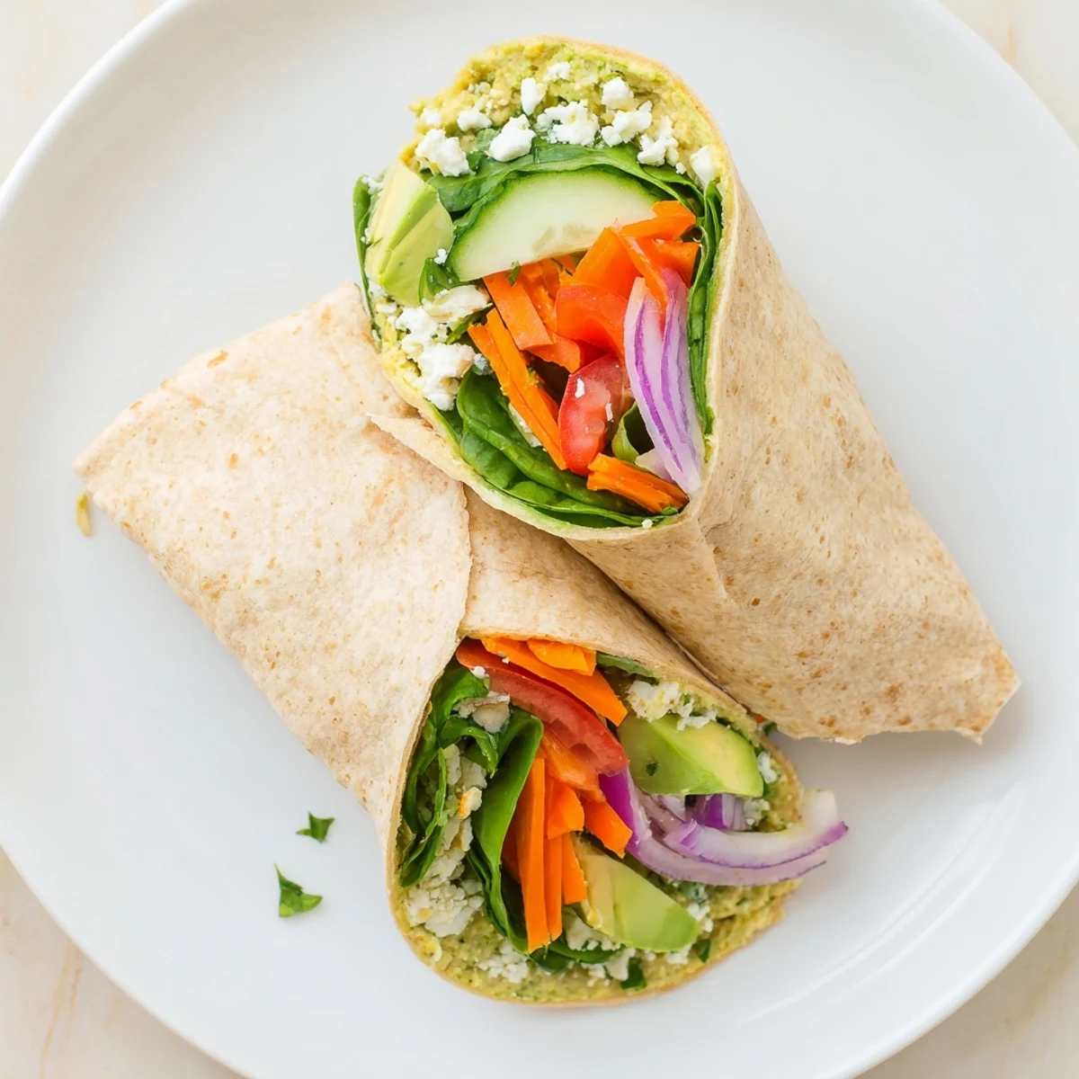 Golden Hummus Veggie Wrap Recipe rolled diagonally showcasing vibrant cucumber, bell peppers, and fresh spinach layers