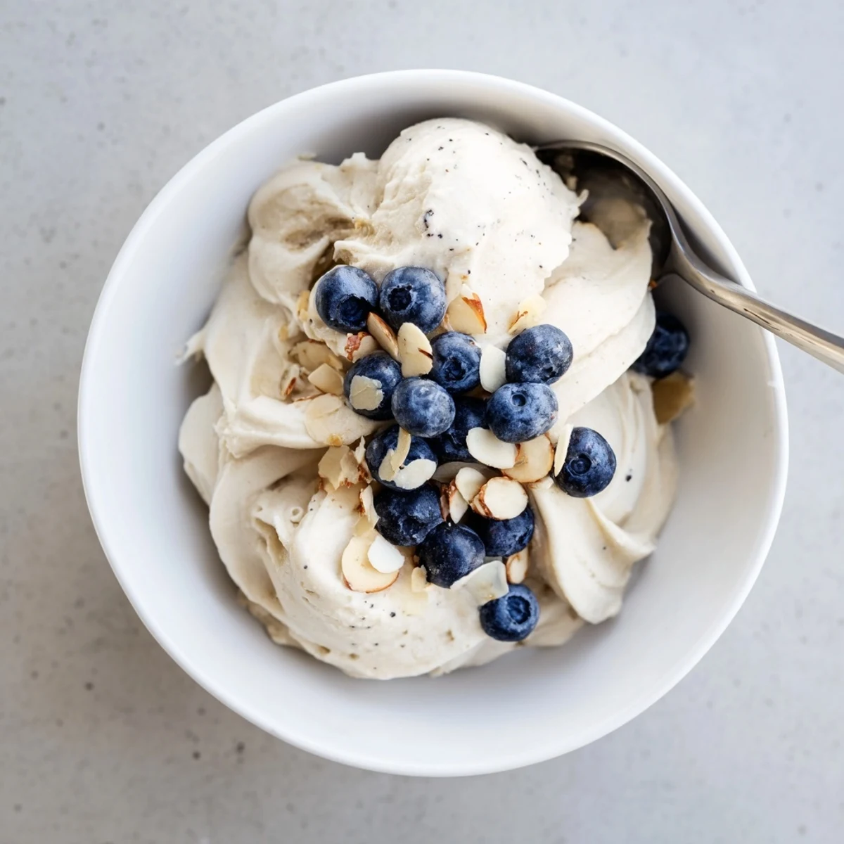 Vegan banana nice cream recipe showing soft serve texture with sliced bananas and crushed nuts