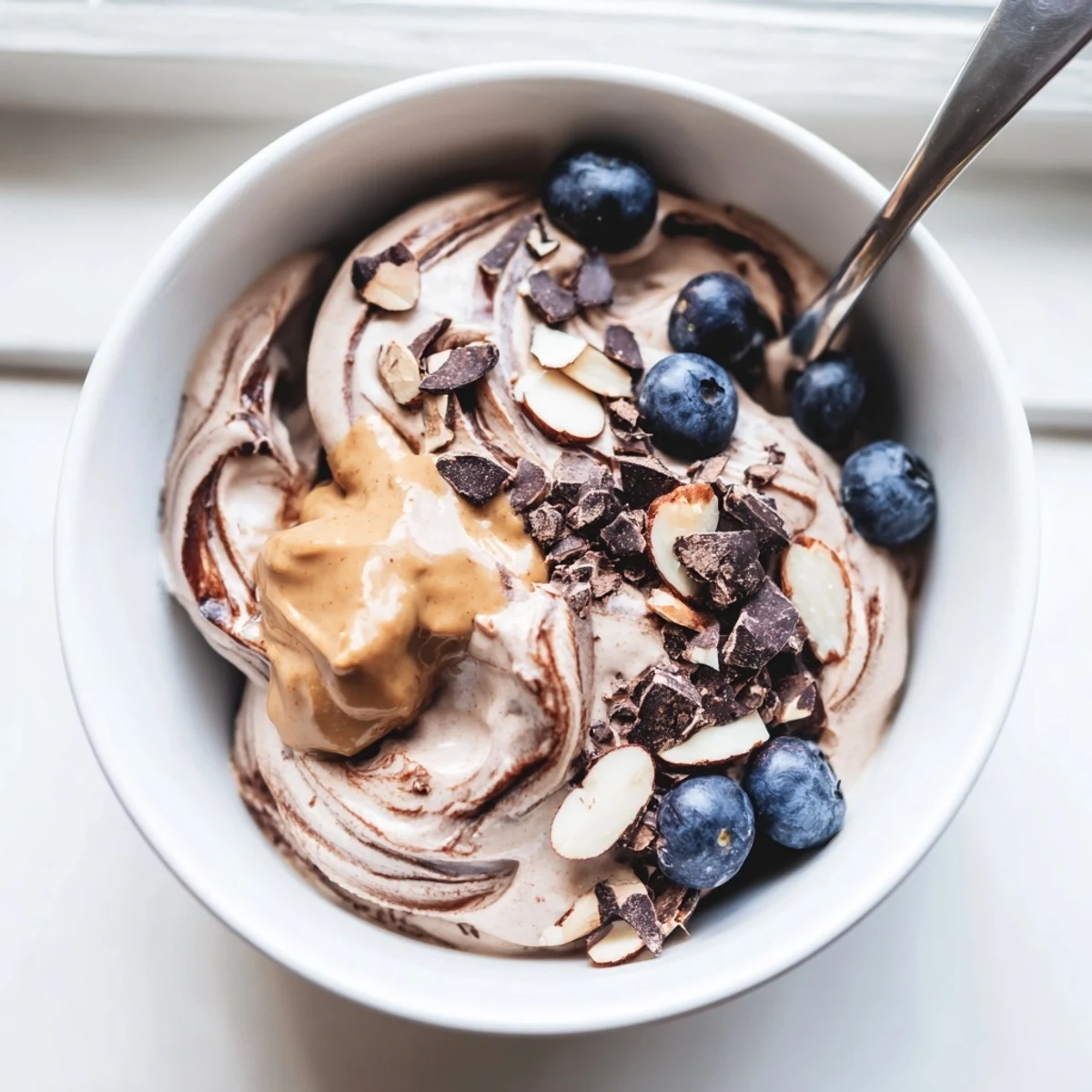 Creamy healthy nice cream recipe served in a bowl with fresh banana slices and dark chocolate shavings