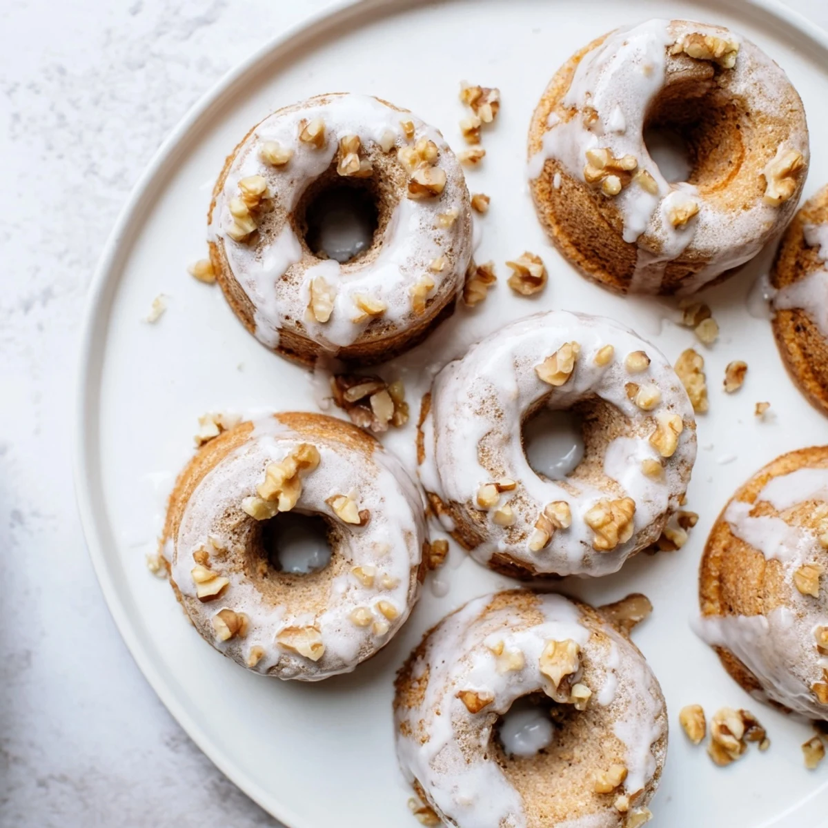 Freshly baked banana bread donuts cooling on wire rack with optional vanilla glaze topping