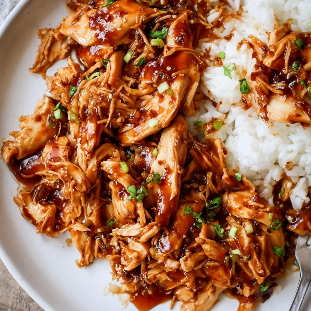 Shredded Crockpot Honey Garlic Chicken fragrant with ginger and honey, garnished with parsley
