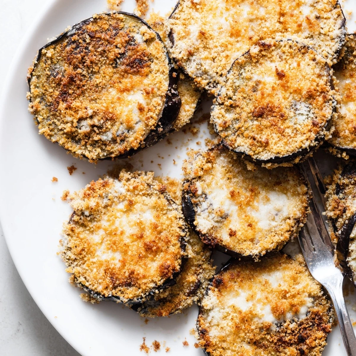 Golden Crispy Baked Eggplant rounds, oven-baked to crisp edges, ideal appetizer.