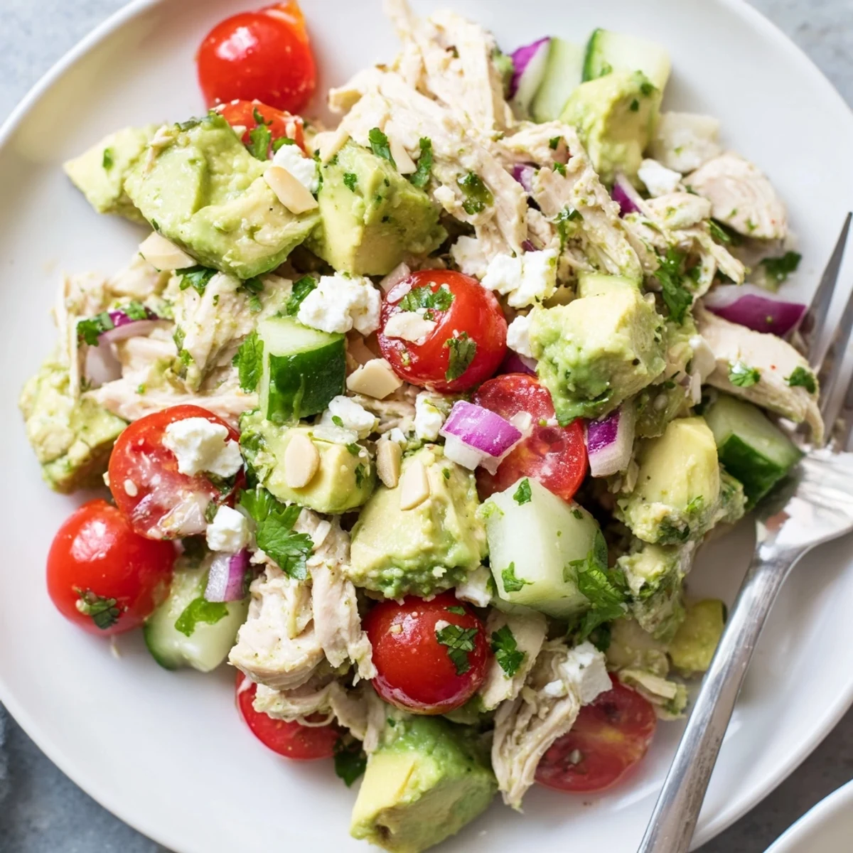 Bright Avocado Chicken Salad tossed with cherry tomatoes, crisp cucumber, and cilantro