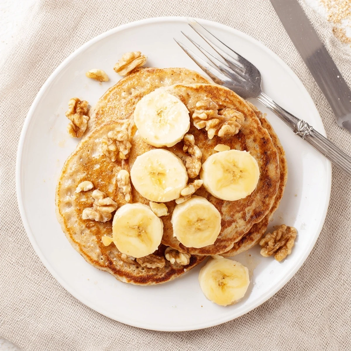 Fluffy protein banana pancakes cooking on a griddle with bubble textures visible