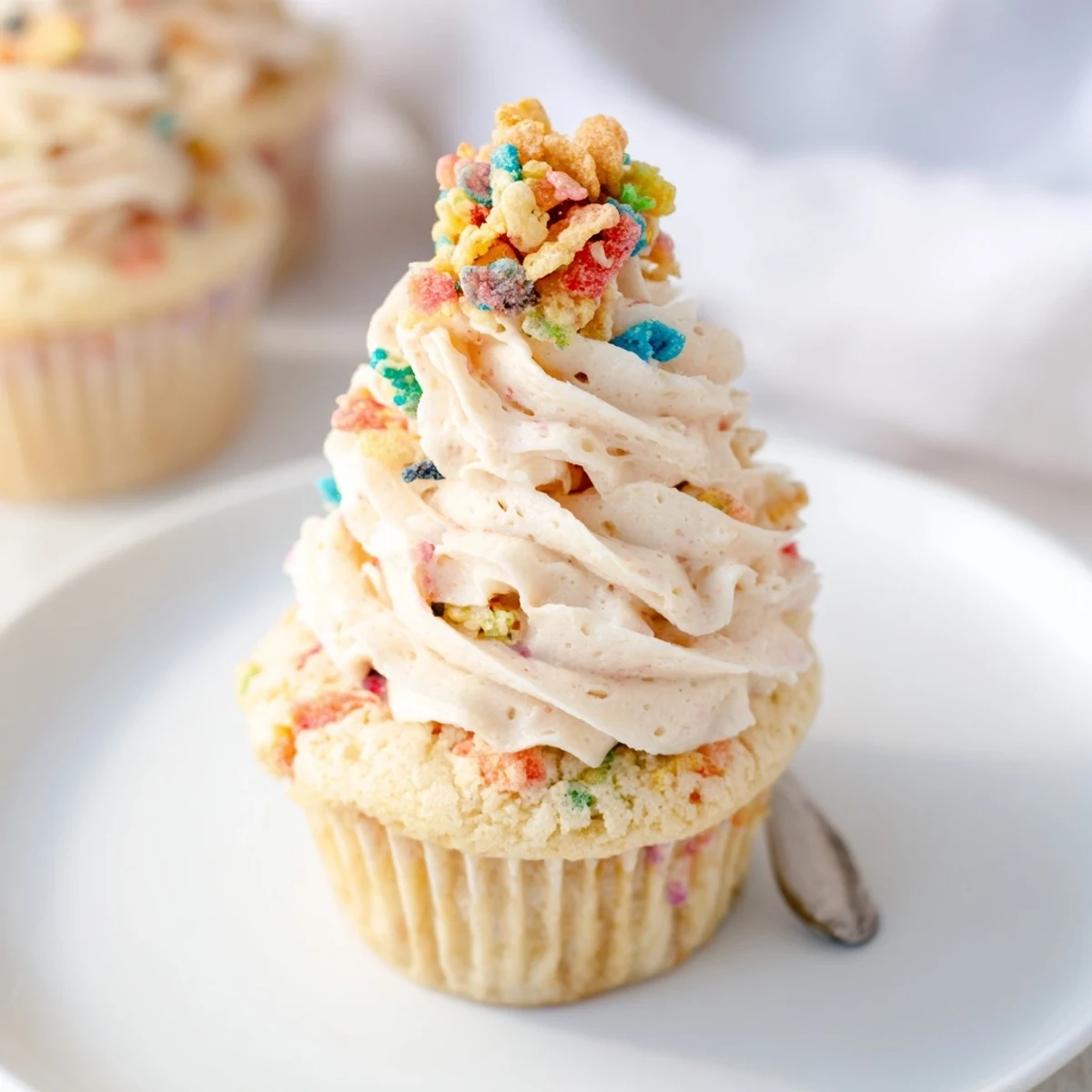 Silky Fruity Pebbles Cereal Frosting swirled smooth, topped with rainbow crunch.