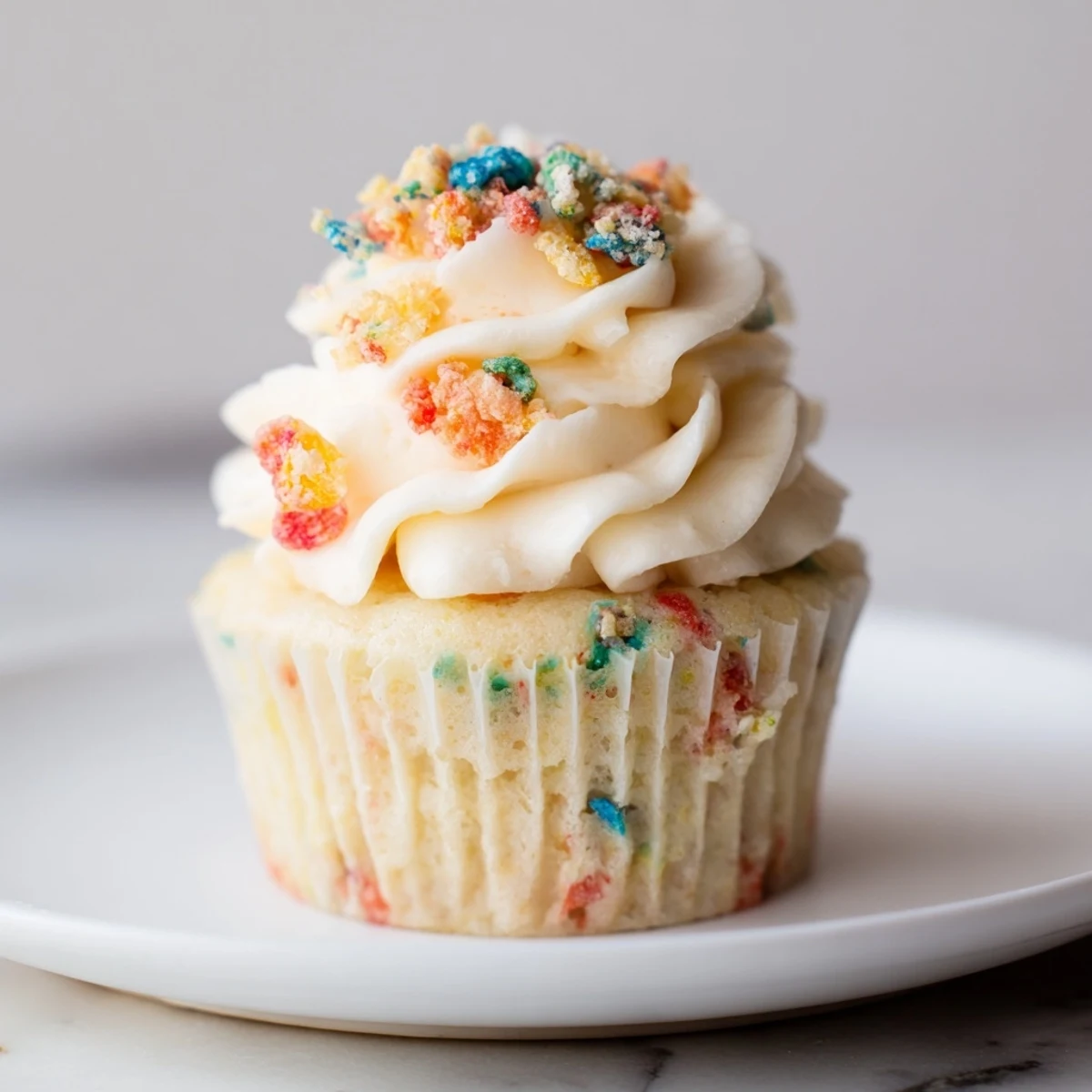 A bowl of Fruity Pebbles Cereal Frosting ready to spread on cookies.