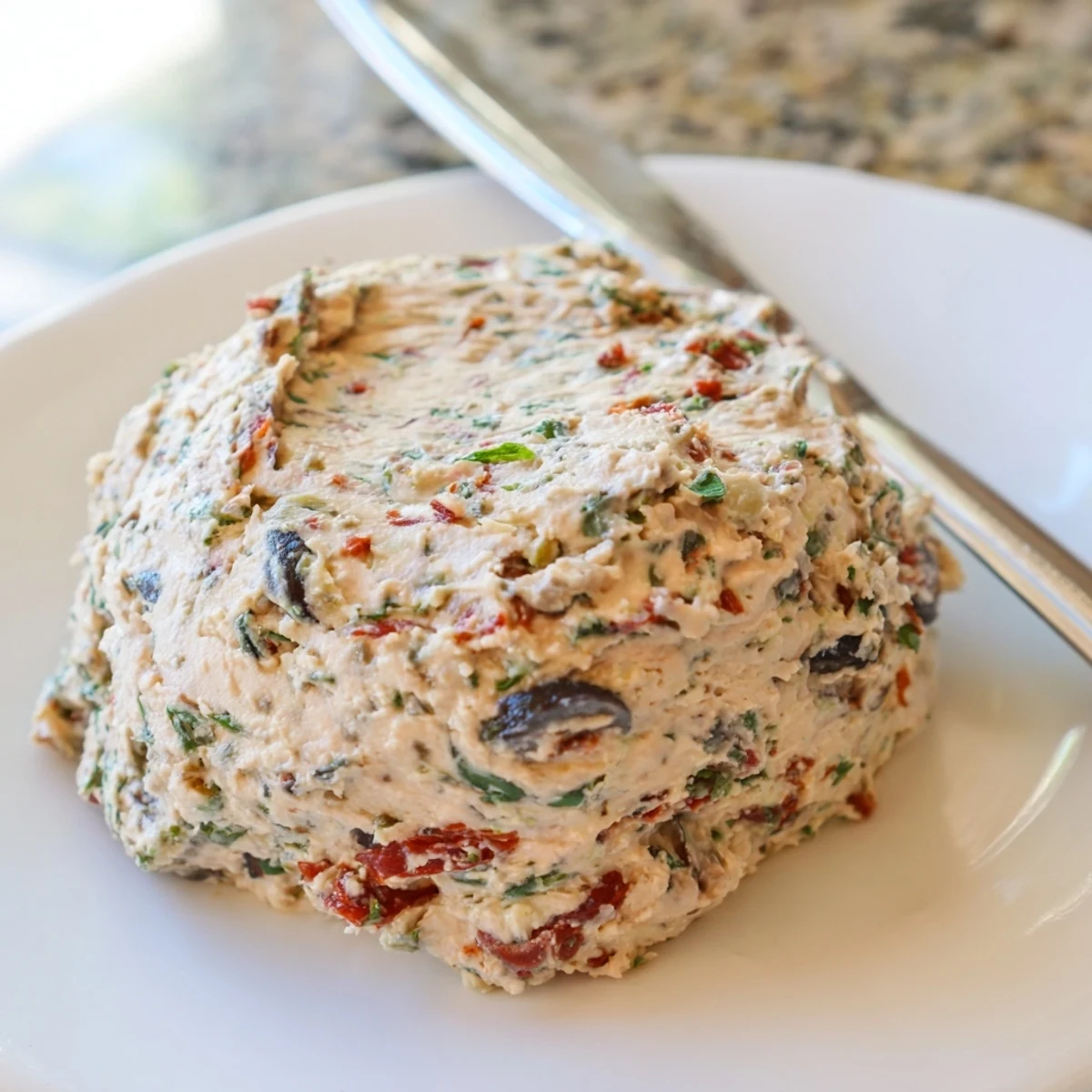 Creamy Italian Style Olive and Cheese Spread served on golden crostini with fresh basil