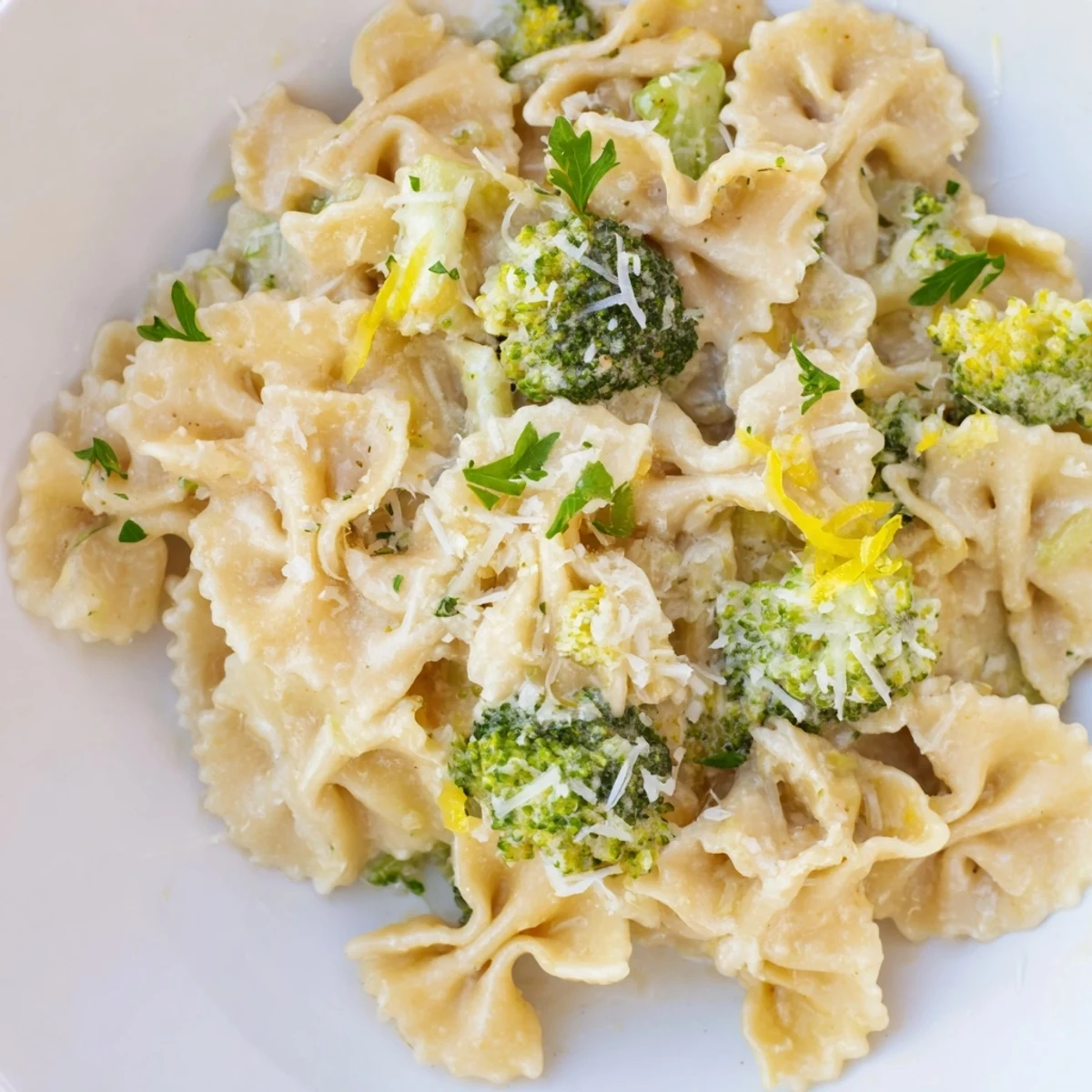 Golden ribbons of mafaldine pasta limone broccoli glistening with buttery lemon cream and fresh herbs