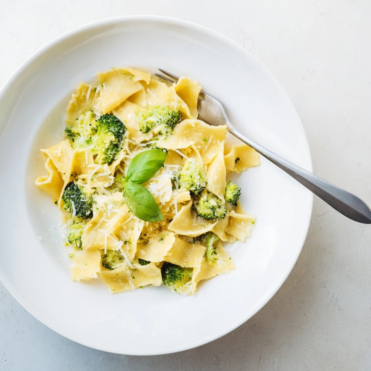 Golden mafaldine ribbons coated in zesty lemon cream sauce with vibrant green broccoli florets