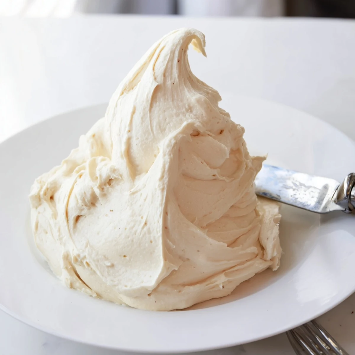 Creamy Italian meringue buttercream swirled atop a golden layered vanilla cake